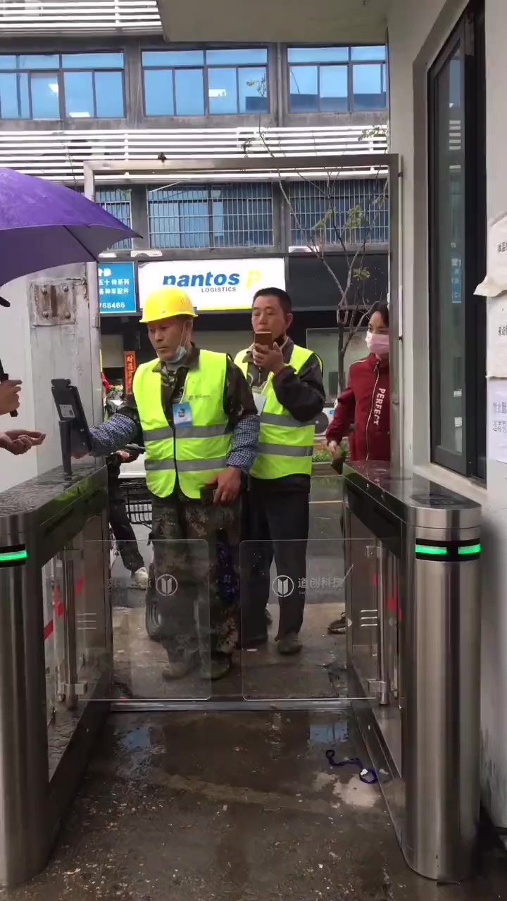 工人在闸机式电子哨兵前扫码进场